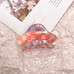 Macro detail of a large acetate hair claw clip with colorful laser checkered pattern