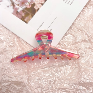 Detailed macro view of large pink gradient acetate hair claw clip with geometric pattern