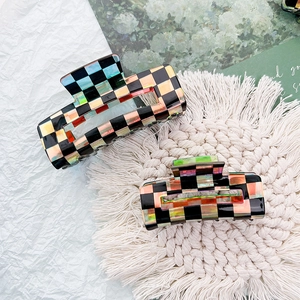 Detail of laser acetate checkerboard hair claw clip with holographic grid pattern