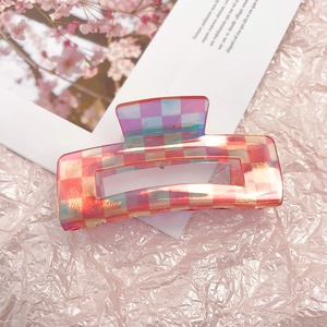 Detail of pink checkerboard acetate hair claw clip with holographic resin finish