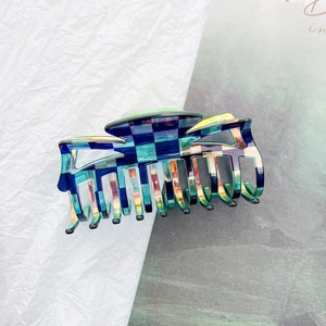 Detail shot of a large checkerboard hair claw clip with colorful iridescent holographic finish