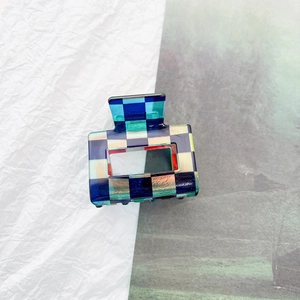 Detail of checkered hair claw clip in blue and green acetate with rectangle cutout