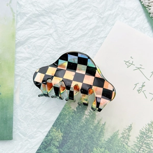 Close-up of checkerboard hair claw clip with holographic finish on aesthetic background