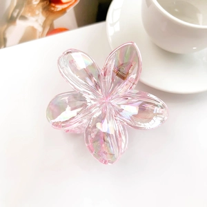 Close-up of iridescent pink flower hair claw clip with metallic spring on a white surface