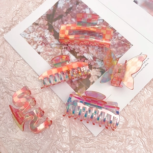 Pink checkered acetate hair claws set with various geometric shapes in a soft gradient style