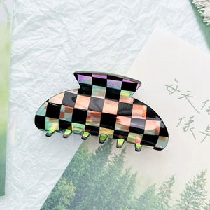 Detail view of checkerboard pattern hair claw clip with black and iridescent finishes