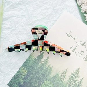 Detail shot of holographic checkerboard hair claw clip with strong metal spring