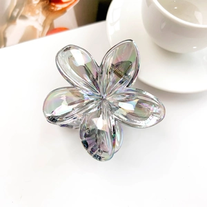 Detail showing the iridescent frosted resin flower hair claw with a metal spring