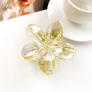 Detail view of the iridescent plumeria hair claw clip showing a gold metal spring