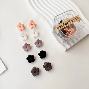 Vue détaillée de mini pinces à cheveux fleurs mates en boîte transparente, plusieurs couleurs