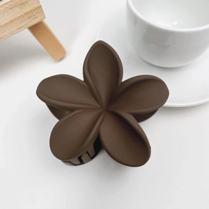 Détail de la pince à cheveux mate café en forme de fleur pour coiffures élégantes
