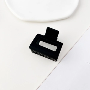 Dettaglio della molletta per capelli quadrata nero opaco dal design geometrico