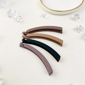 Set of four matte banana hair clips in brown tones featuring internal teeth for firm grip