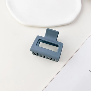 Dettaglio di una molletta per capelli quadrata blu opaco con design a incavo