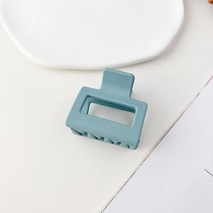 Dettaglio della molletta quadrata opaca in blu morandi con design cavo minimalista