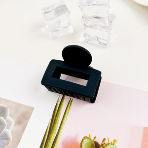 Dettaglio del fermaglio per capelli rettangolare nero opaco con design a intaglio