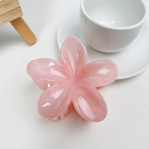 Vue détaillée de la pince à cheveux frangipanier rose en résine brillante et lisse