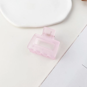Dettaglio della molletta quadrata rosa opaca con un design rettangolare e cavo