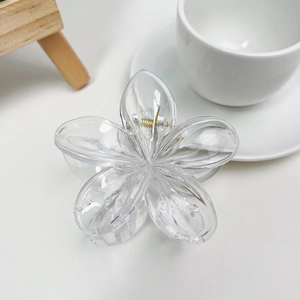 Vue de dessus d'une pince à cheveux mate en forme de fleur avec ressort doré