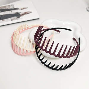 Close-up of four-color matte tooth hairbands on a white ceramic flower plate