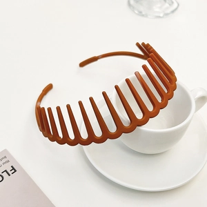 Detail view of amber brown toothed headband made of matte resin on a white table