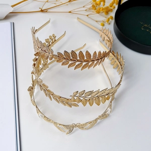 Dettaglio di cerchietti dorati con foglie e accessori decorativi per capelli a farfalla