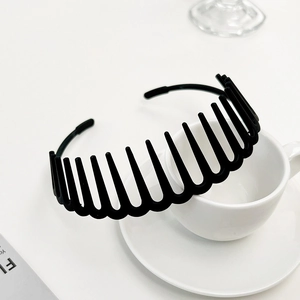 Detail of matte black non-slip hairband with inner teeth against a white cup