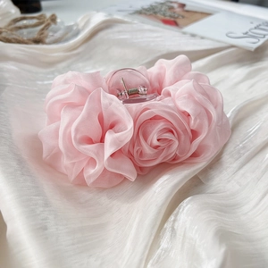Detailansicht der zartrosa Chiffon Rose Haarklammer auf weißem Seidenstoff liegend