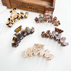 Five assorted large acetate hair claws with marble and tortoiseshell patterns in various colors