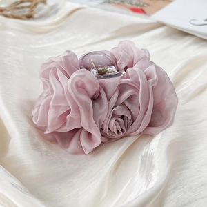 Detailansicht der Haarspange aus plissiertem Chiffon in Altrosa auf Seidenstoff