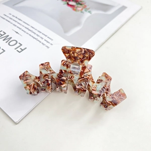 Close-up of a large amber tortoiseshell hair claw clip with smooth geometric curves