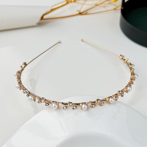 Dettaglio del cerchietto da sposa a foglie dorate con perle bianche e strass lucenti