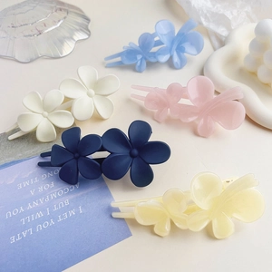 Macro shot of matte resin floral hair clips in five colors showing frosted texture and detail
