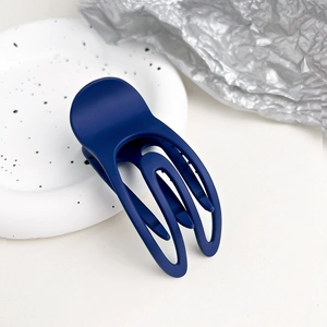 Dettaglio di un fermaglio per capelli blu scuro opaco con una texture liscia e satinata