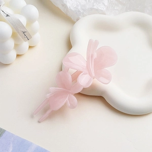 Close-up of pink frosted jelly butterfly hair clip on a white cloud-shaped ceramic tray