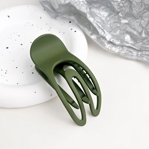 Dettaglio della molletta per capelli opaca verde oliva con design vuoto minimalista