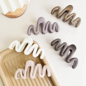 Detailed macro view of large matte wavy hair claws in five elegant Morandi colors