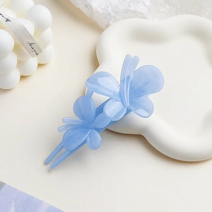 Detail of light blue butterfly hair clip with double matte finish on ceramic tray