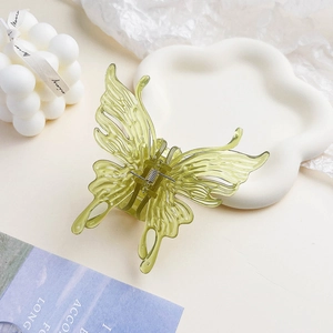Détail macro de la pince à cheveux papillon vert clair translucide avec ailes en résine