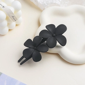 Detail of matte black double flower hair clip with elegant frosted texture for women