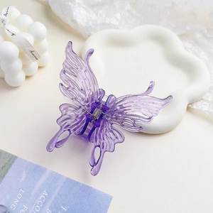 Gros plan sur la pince à cheveux papillon violette translucide avec des ailes texturées