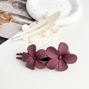 Detailed view of matte flower duckbill clips in beige and dark purple floral design