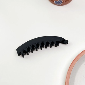 Dettaglio del fermaglio per capelli a banana nero opaco con denti ad incastro