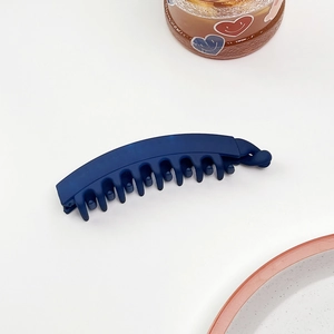 Dettaglio del fermaglio a banana blu opaco con denti a incastro e chiusura finale