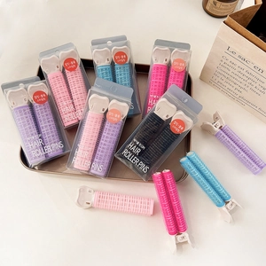 Detailed view of hair roller pins in various colors on a golden decorative tray