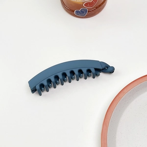 Dettaglio molletta a banana blu scuro opaco con denti fini per una presa sicura