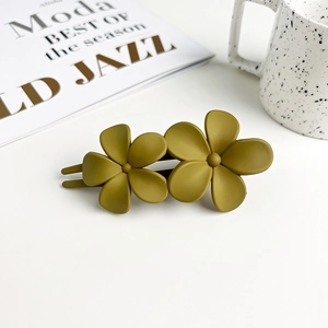 Detail of matte olive green double flower hair clip on a minimalist white background