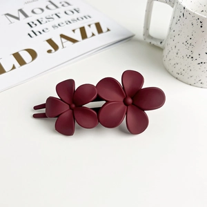 Detail view of double flower matte hair clip in elegant burgundy red finish