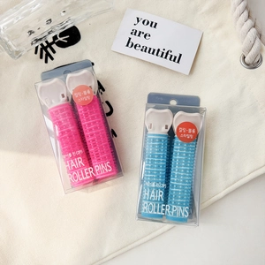 Detail view of pink and blue self-grip hair rollers with white clips in clear packaging