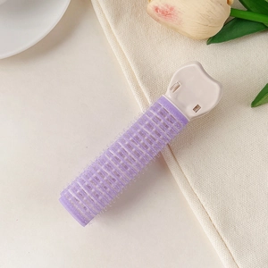 Macro detail of a purple velcro hair roller clip for root volume on a soft background
